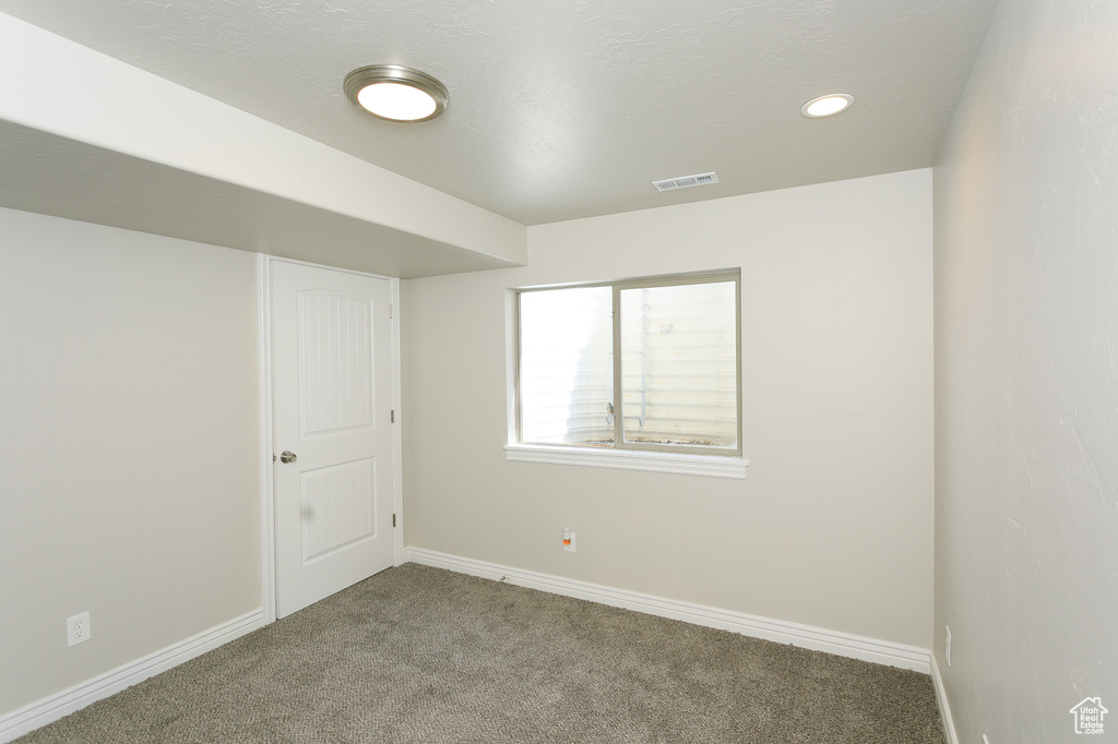 Carpeted empty room featuring baseboards and recessed lighting