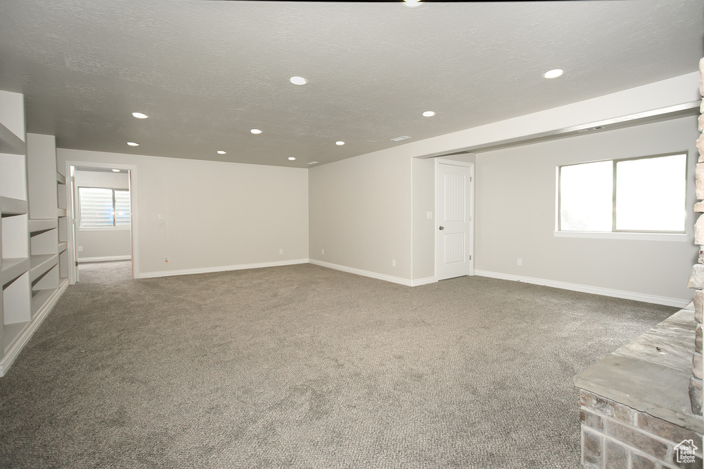 Unfurnished living room featuring recessed lighting, carpet, and a textured ceiling