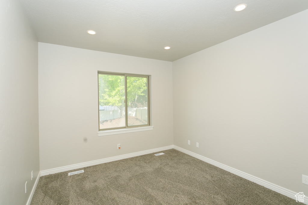 Carpeted empty room featuring recessed lighting