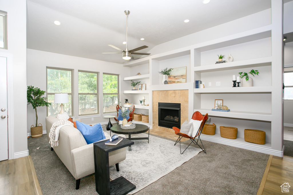Living area featuring ceiling fan, built in features, a fireplace, wood finished floors, and recessed lighting