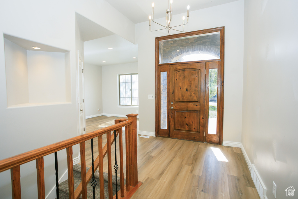 Entryway featuring light wood-type flooring, a chandelier, and recessed lighting