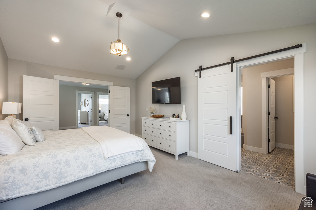 Bedroom with a barn door, lofted ceiling, light carpet, and recessed lighting
