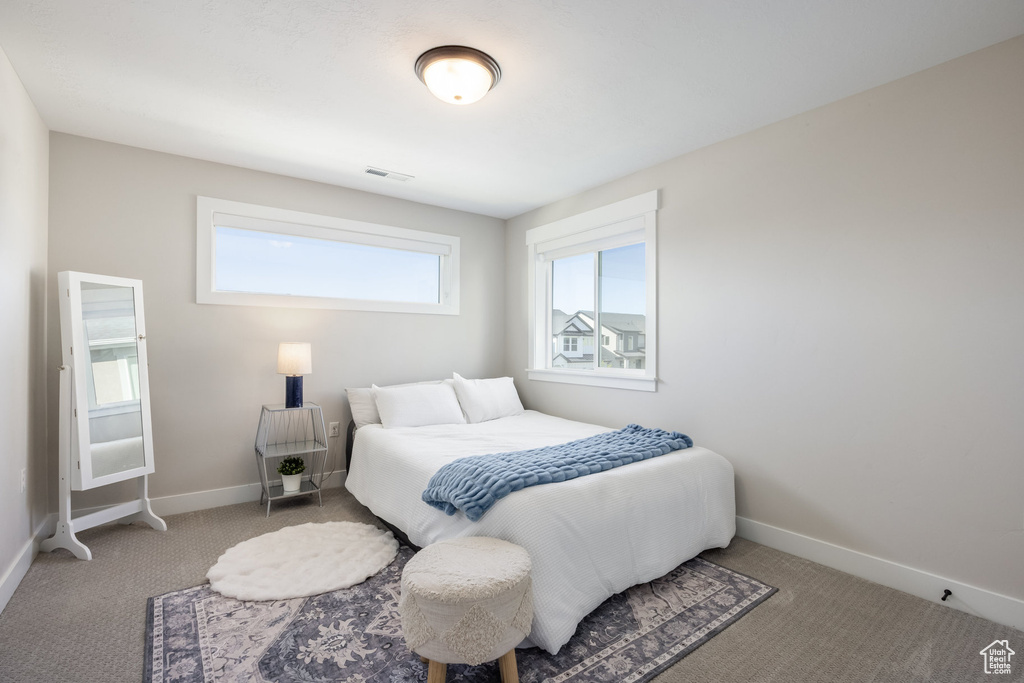Bedroom featuring carpet and baseboards