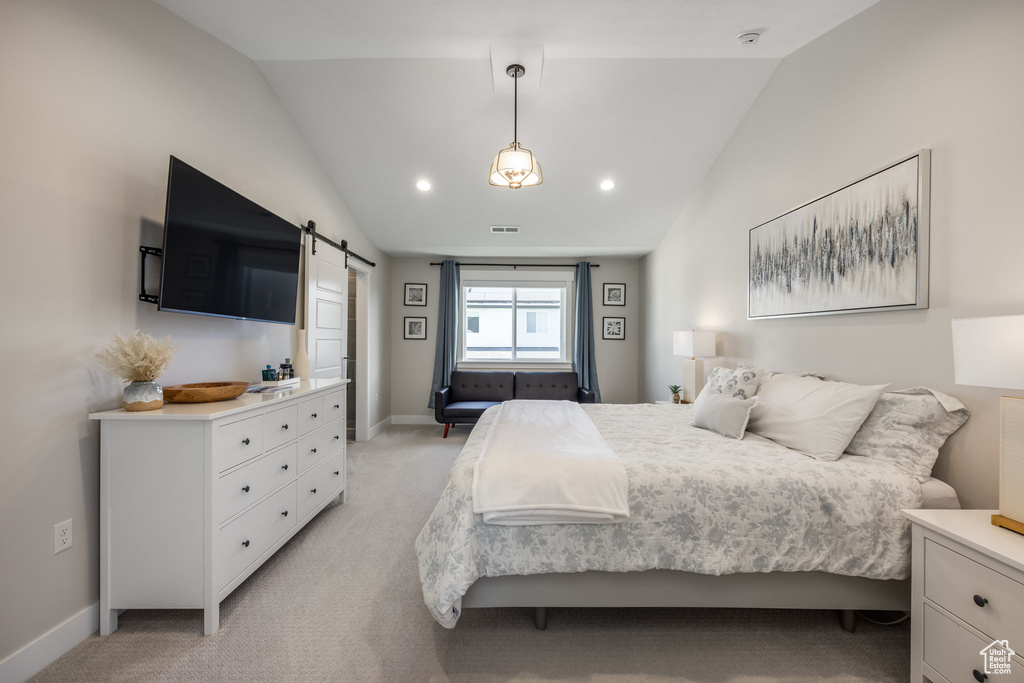 Bedroom with a barn door, vaulted ceiling, light colored carpet, and recessed lighting