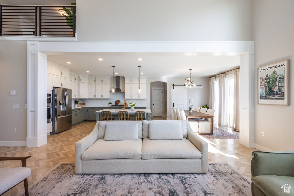 Living area featuring a chandelier, arched walkways, and recessed lighting