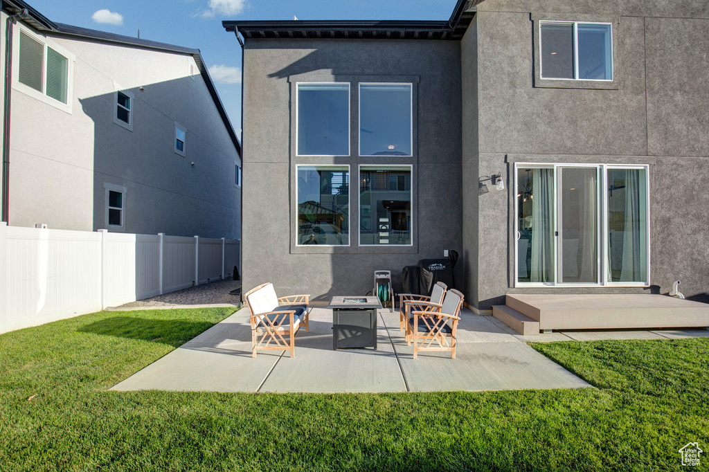 Back of property featuring stucco siding, an outdoor fire pit, and a patio