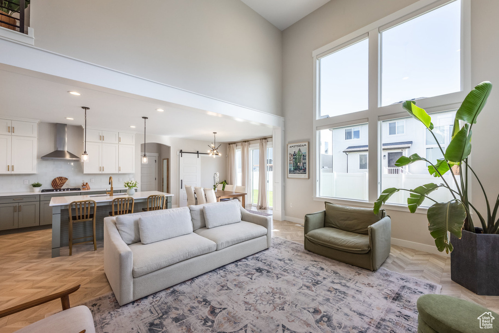 Living area with a towering ceiling, a chandelier, and recessed lighting