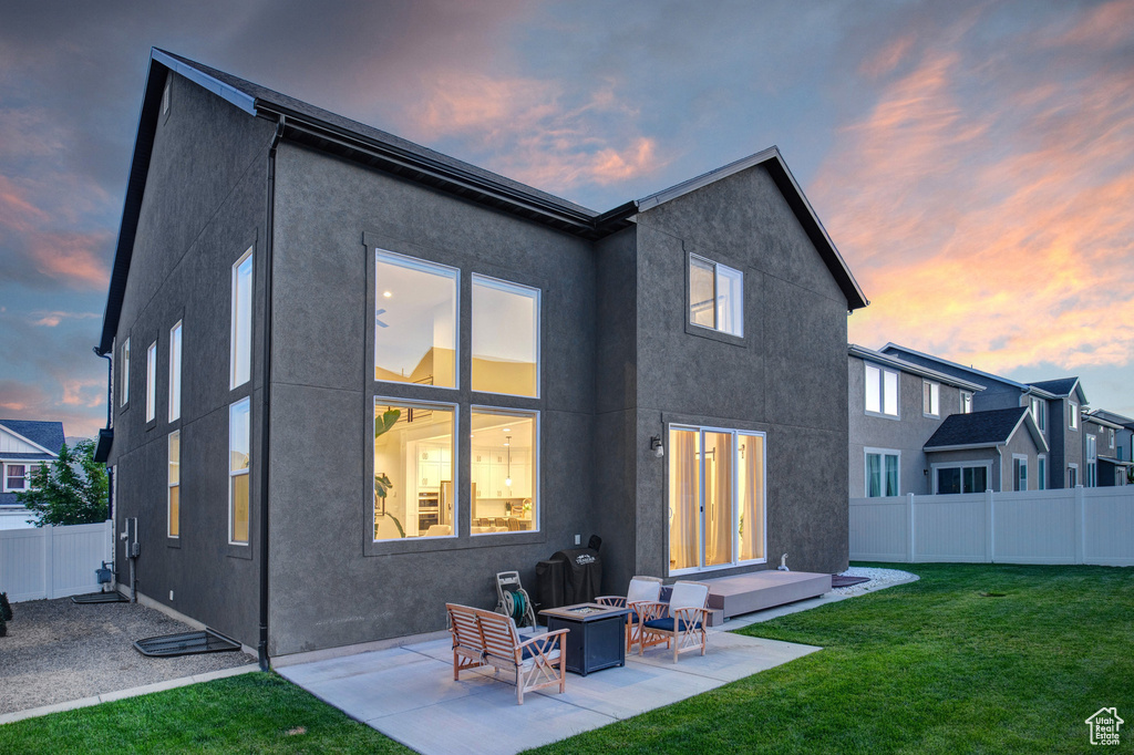 Back of house with a patio, stucco siding, and an outdoor fire pit