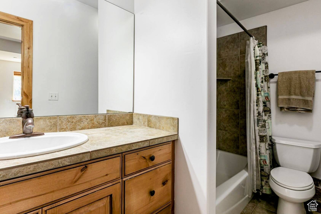 Bathroom with vanity, shower / bath combo, and tile patterned flooring