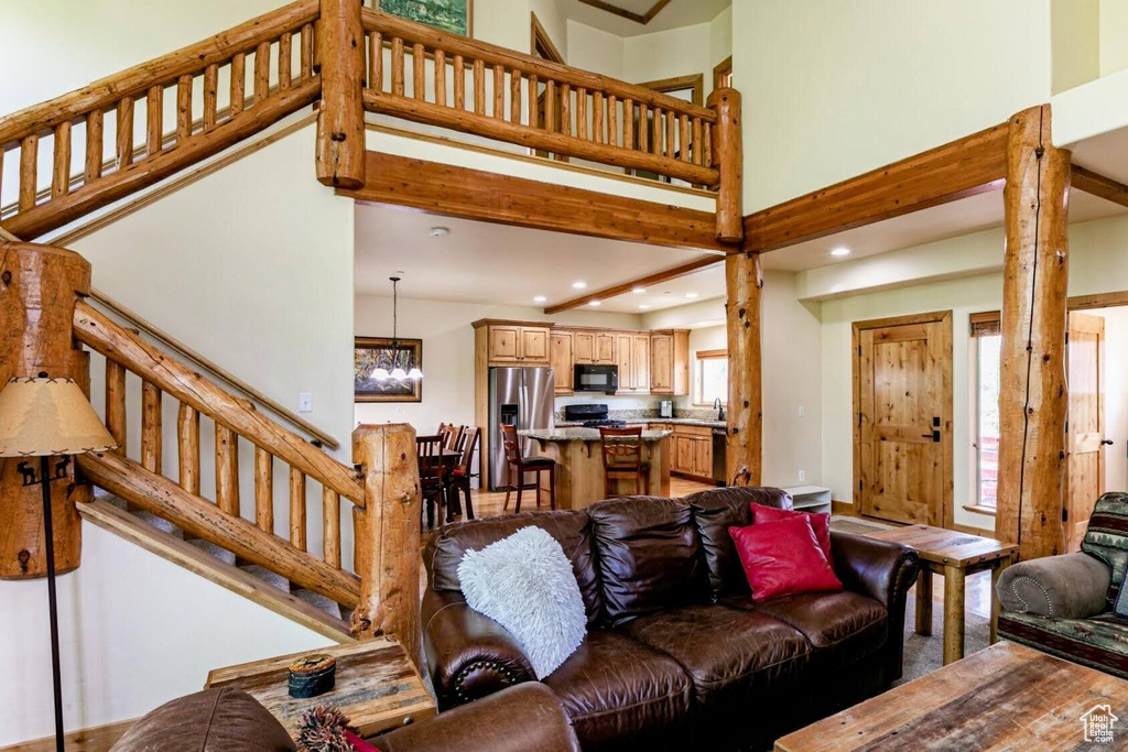 Living area with a chandelier, a towering ceiling, recessed lighting, and stairway