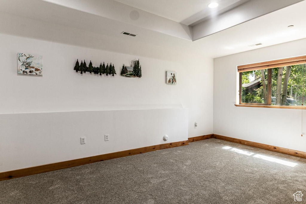 Spare room featuring carpet and baseboards