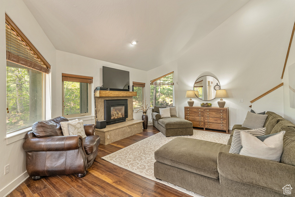 Living area featuring plenty of natural light, wood finished floors, a glass covered fireplace, and recessed lighting
