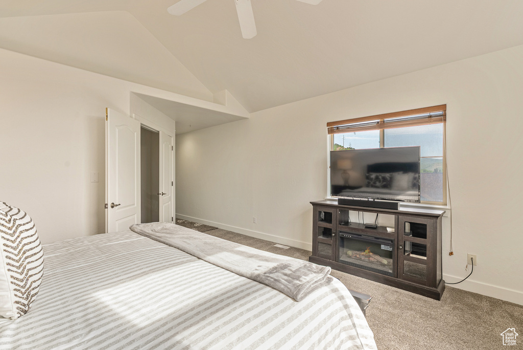 Unfurnished bedroom with lofted ceiling, carpet flooring, and a ceiling fan