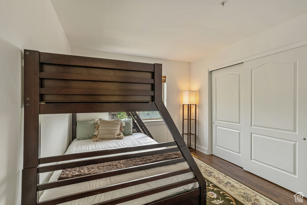 Bedroom with wood finished floors and a closet