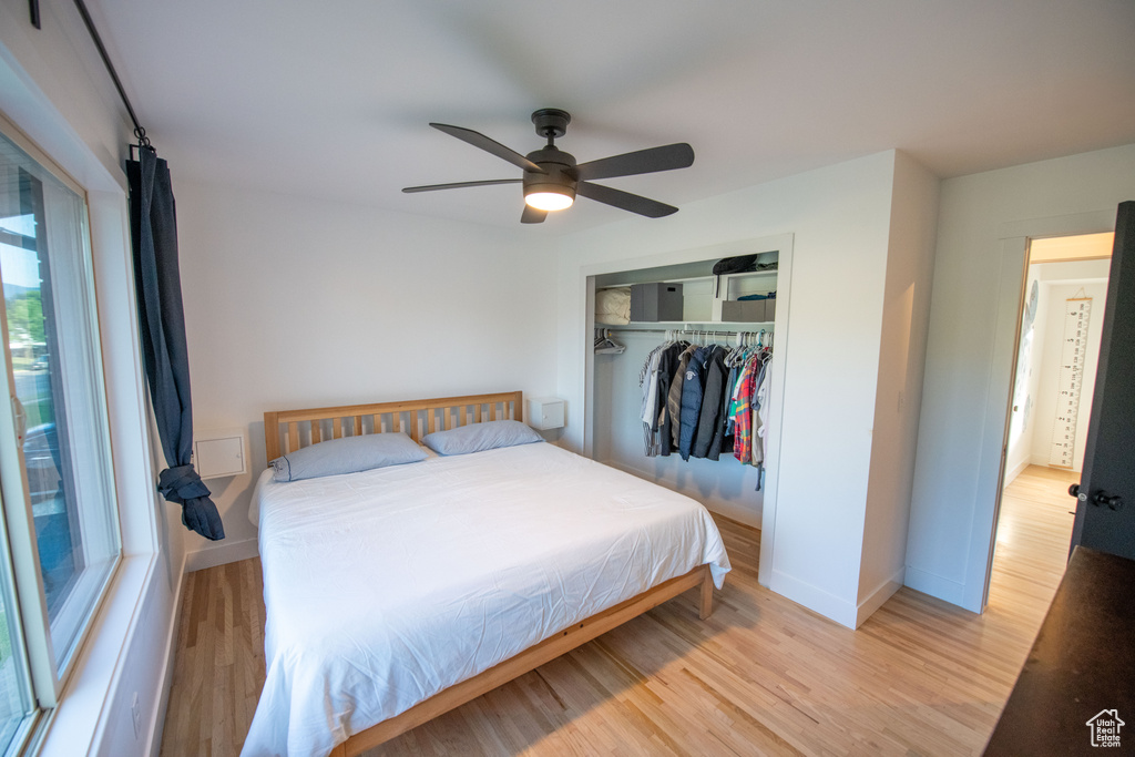 Bedroom featuring light wood-type flooring, a closet, and a ceiling fan