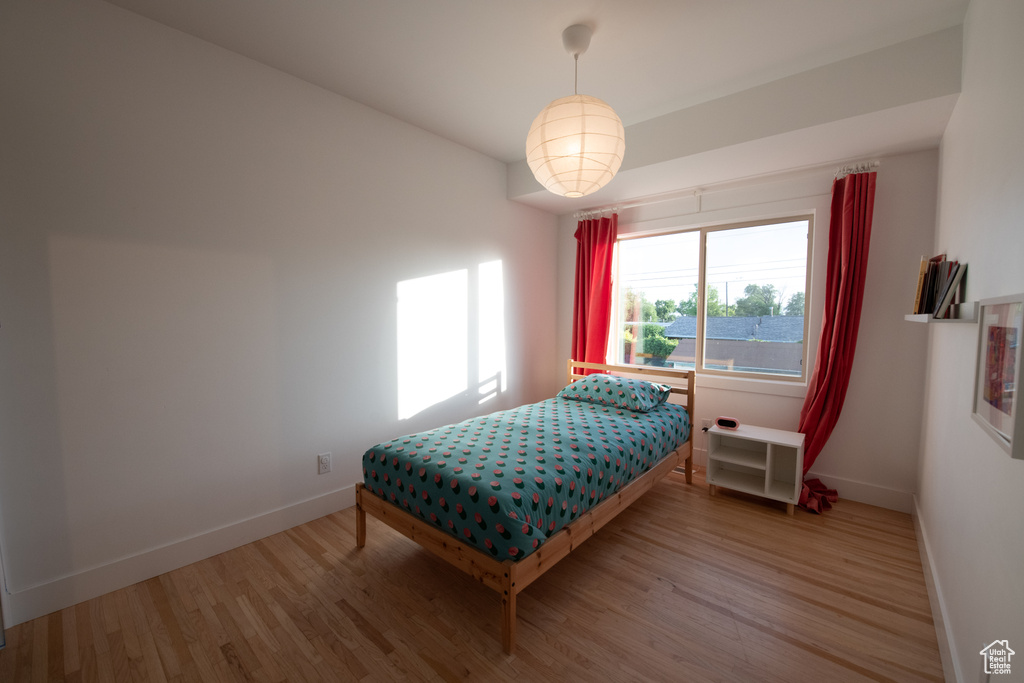 Bedroom with wood finished floors and baseboards