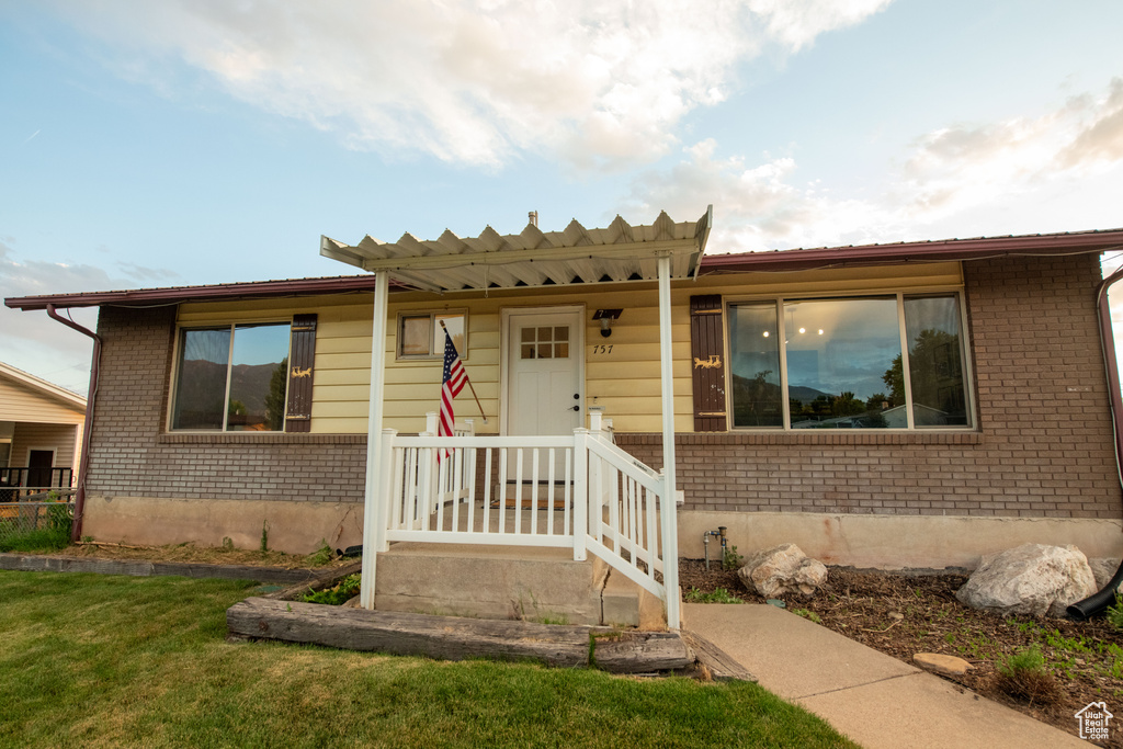 View of front of house with brick siding and a front lawn