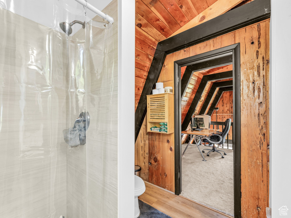 Bathroom featuring vaulted ceiling, a shower, wooden ceiling, and wood finished floors