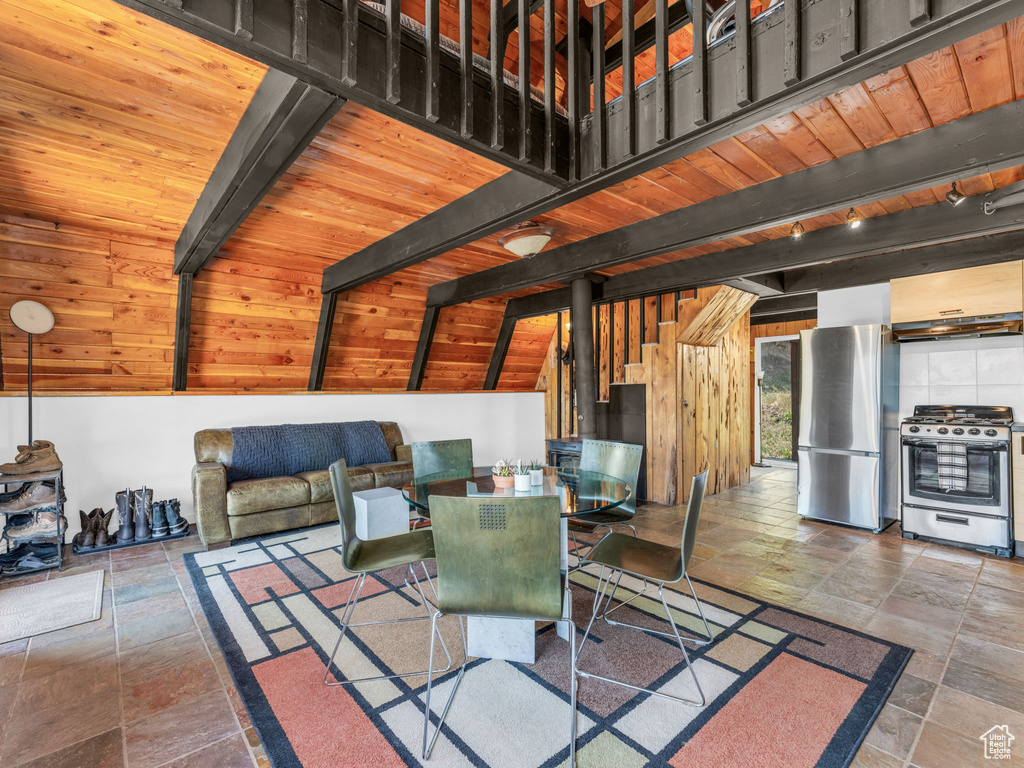 Dining room with stone tile floors and a wooden ceiling with exposed beams