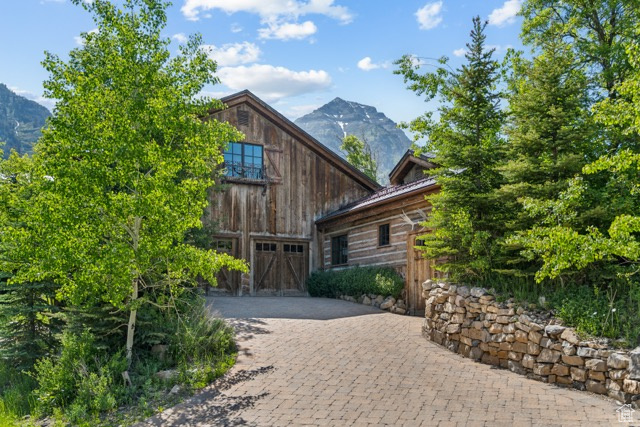View of front of property with a garage, decorative driveway, and a mountain view