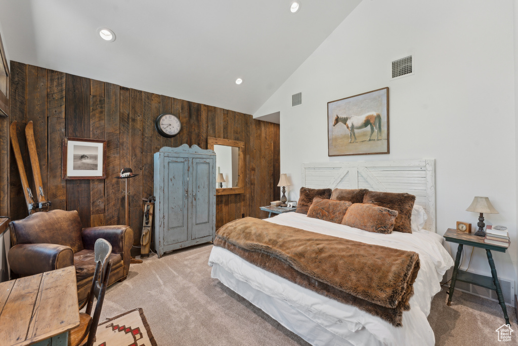 Bedroom with wood walls, carpet, high vaulted ceiling, and recessed lighting