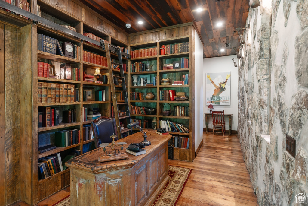 Home office with bookshelves and wood finished floors