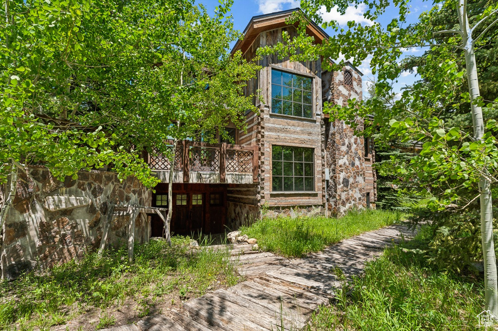 View of side of home featuring a wooden deck