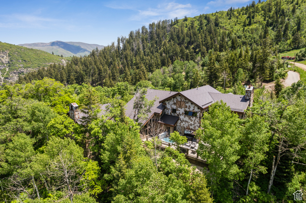 Aerial view of property and surrounding area with a forest