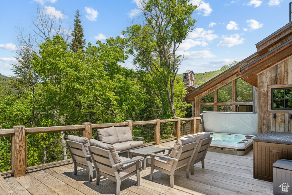 Deck featuring a covered hot tub and outdoor lounge area