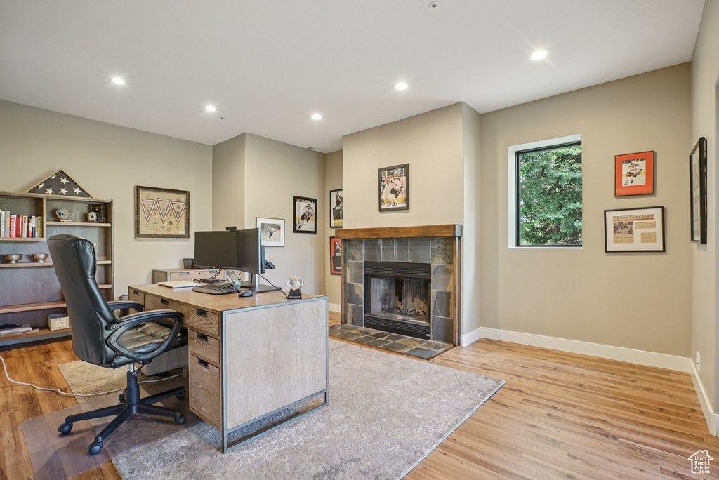 Home office featuring wood finished floors, a tile fireplace, and recessed lighting