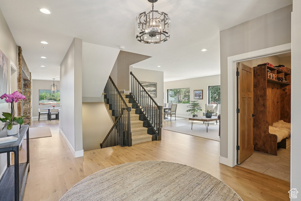 Entrance foyer featuring a chandelier, wood finished floors, recessed lighting, and stairway