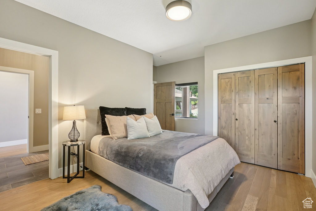 Bedroom with wood finished floors and a closet