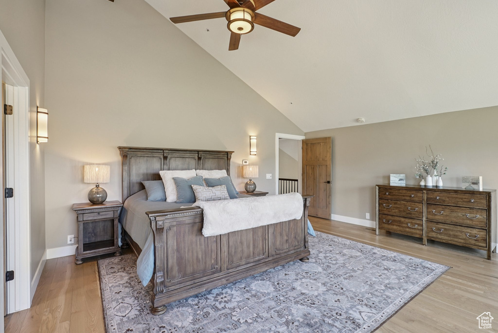 Bedroom featuring high vaulted ceiling, light wood-style floors, and a ceiling fan