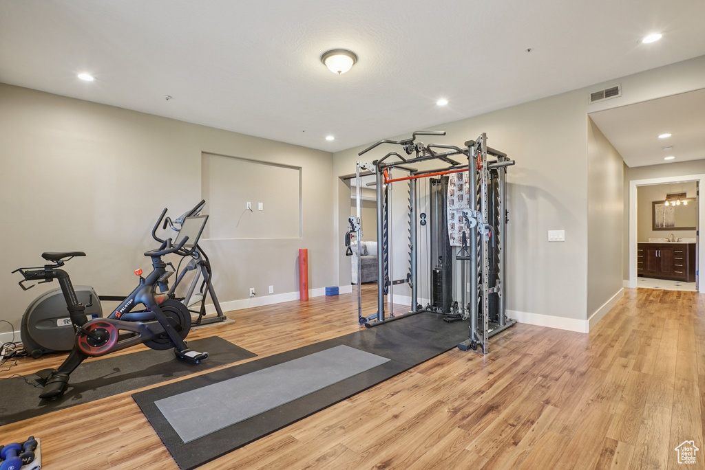 Workout room featuring wood finished floors and recessed lighting