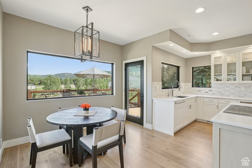 Dining room featuring light wood-style flooring, a chandelier, and recessed lighting