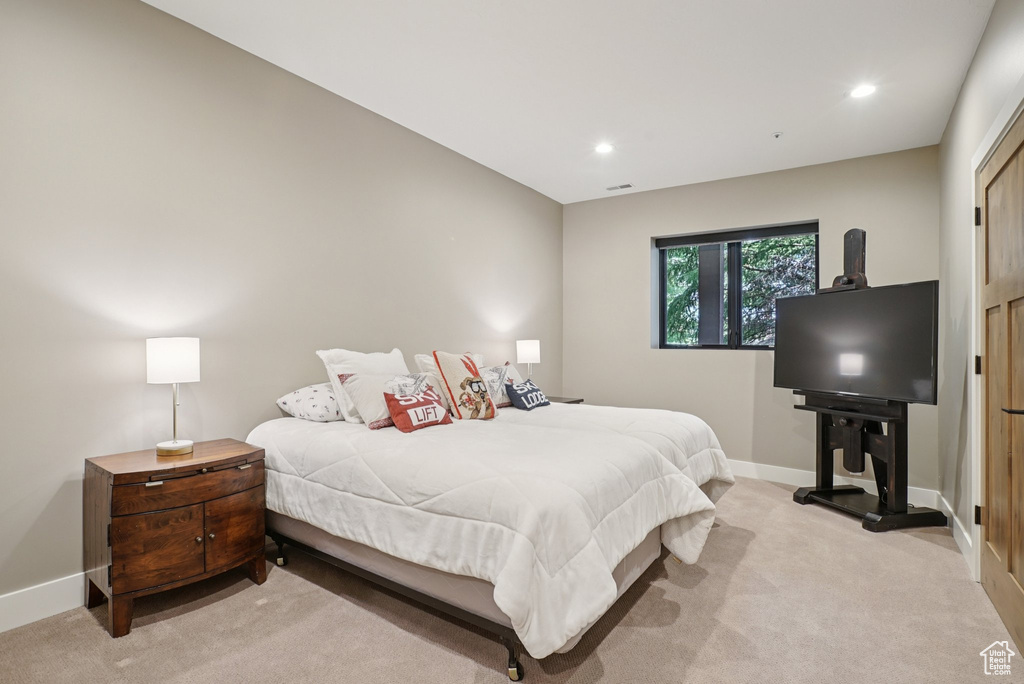 Bedroom with light colored carpet and recessed lighting