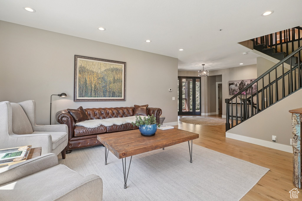 Living room featuring a chandelier, stairs, recessed lighting, and light wood-style flooring