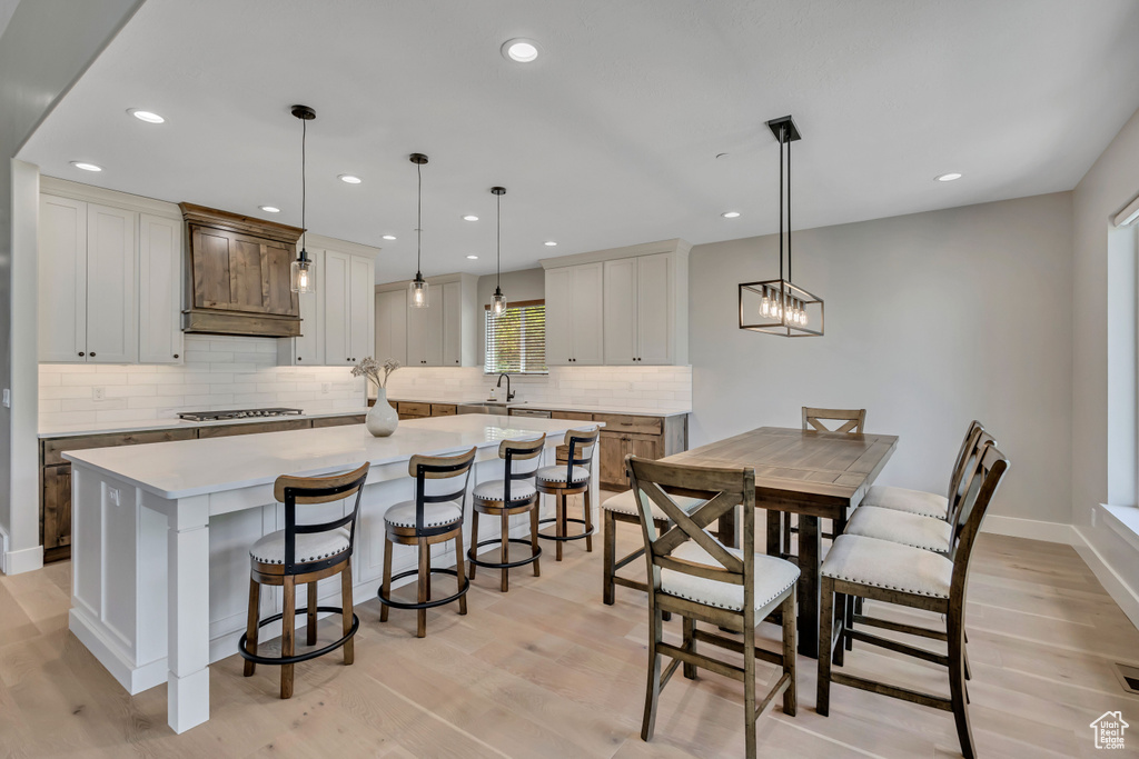 Dining space with light wood-style floors and recessed lighting