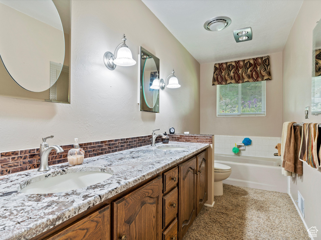 Bathroom with double vanity, a garden tub, and decorative backsplash