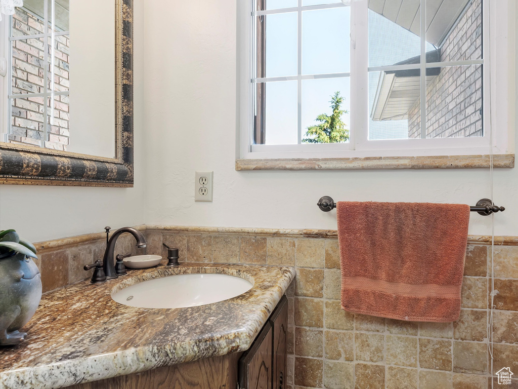 Bathroom with vanity, tile walls, and wainscoting