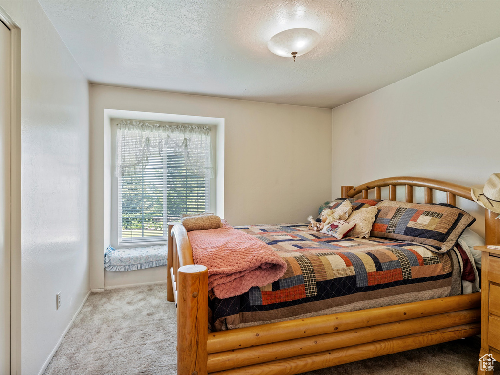 Bedroom featuring carpet and a textured ceiling