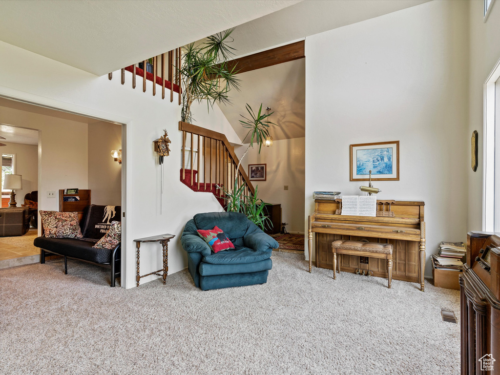 Carpeted living room featuring stairway