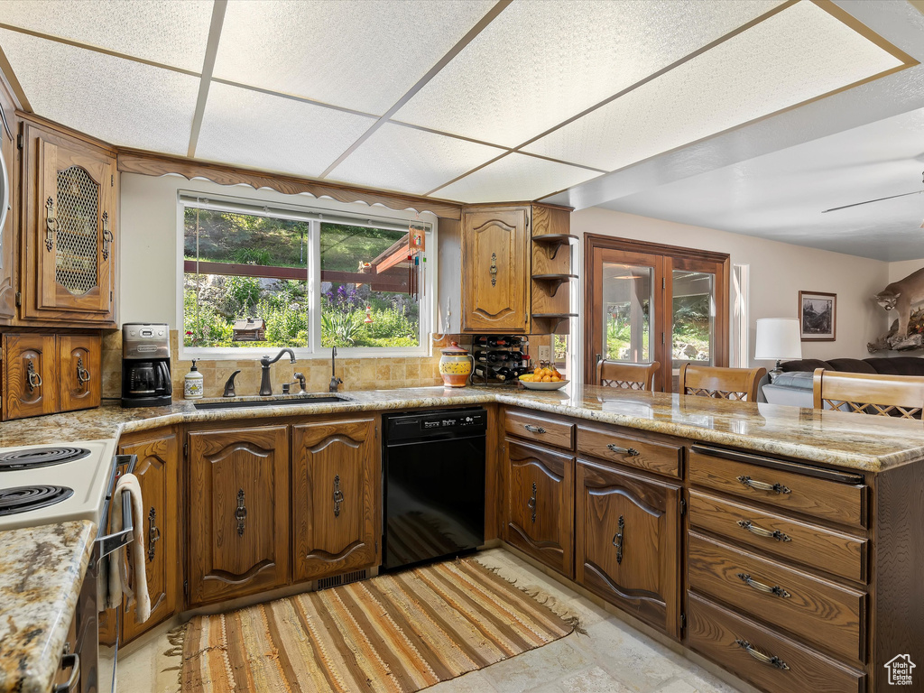 Kitchen with black dishwasher, electric range oven, a peninsula, open shelves, and light countertops