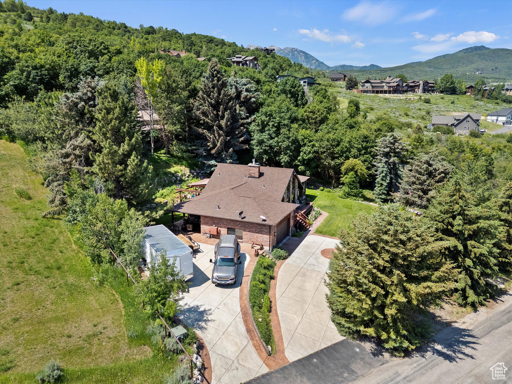 Aerial view of property and surrounding area with a mountain backdrop