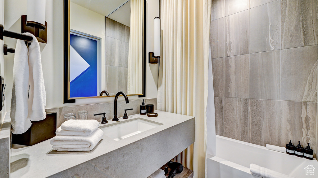 Bathroom featuring shower / bath combination with curtain and vanity