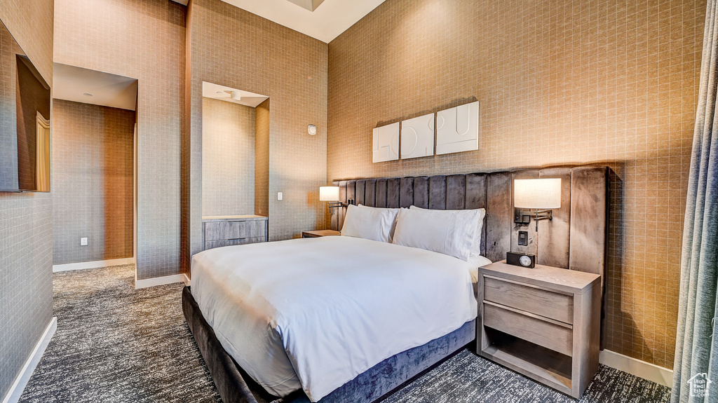 Bedroom with a high ceiling and baseboards