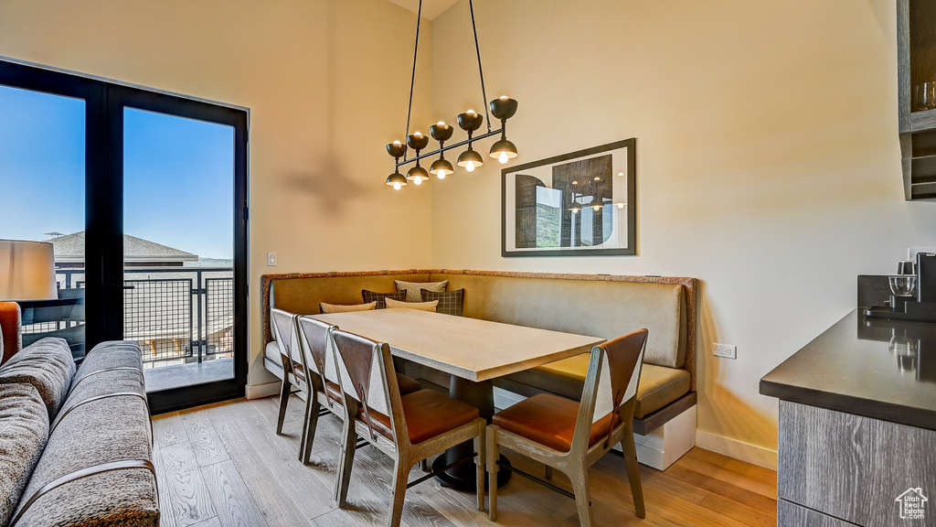 Dining space featuring light wood finished floors, a high ceiling, and breakfast area
