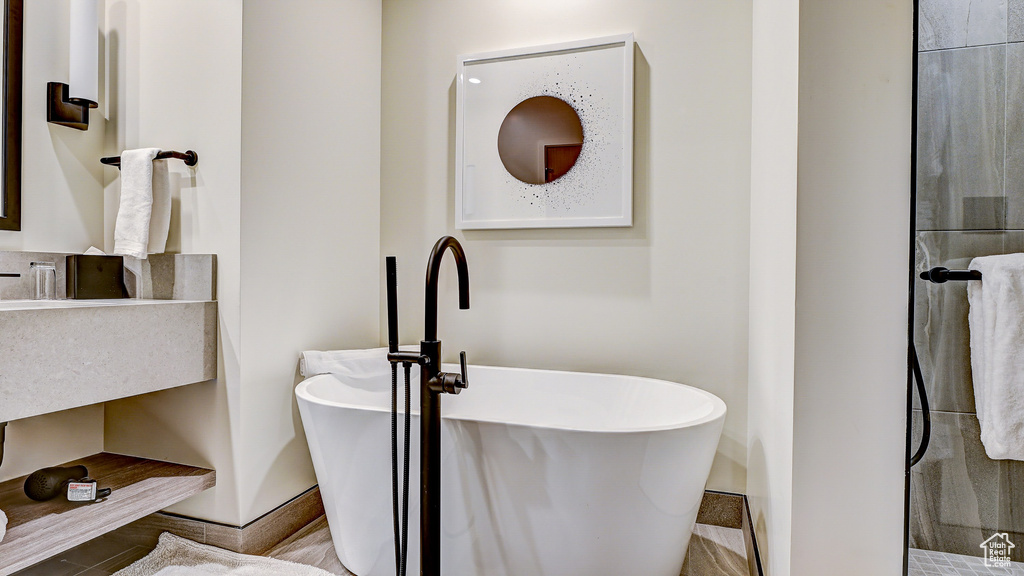 Bathroom featuring a freestanding bath, a shower, and vanity