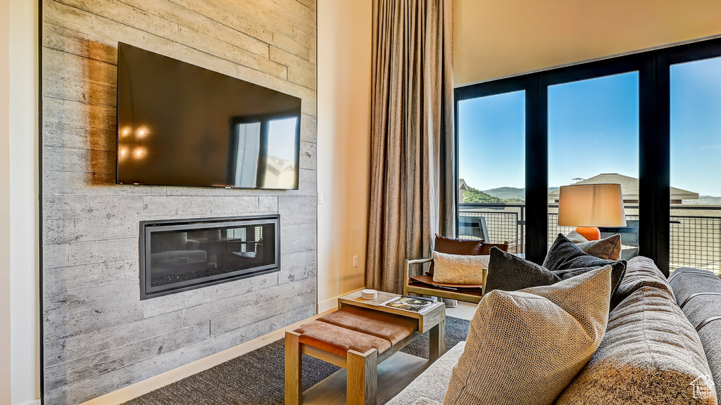 Carpeted living room featuring a glass covered fireplace and baseboards