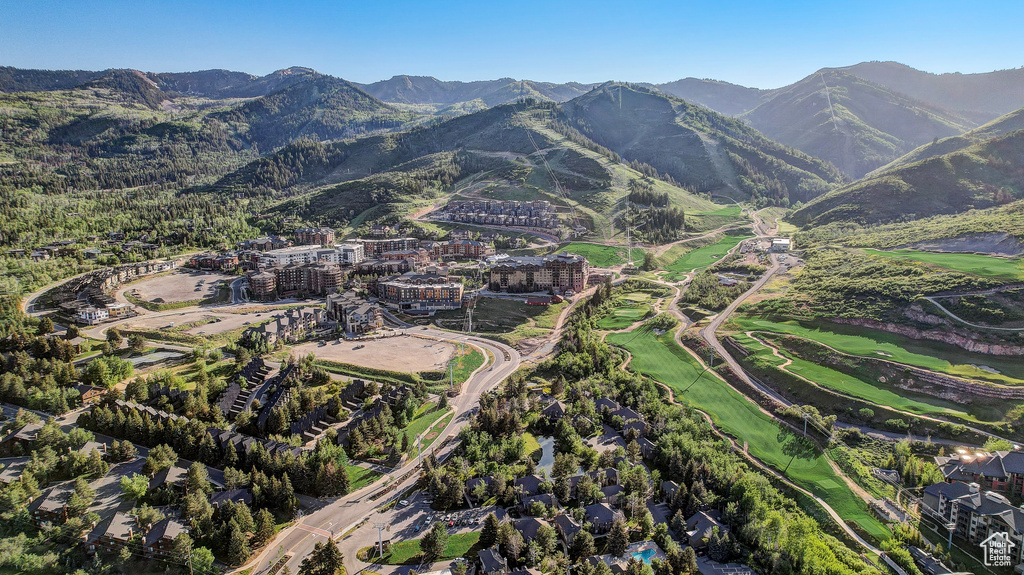 Aerial view of property\'s location with a mountain backdrop and a local golf course